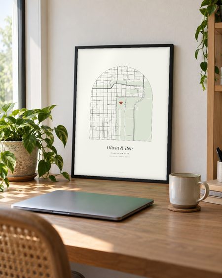 Arch map poster, black frame, leaning on a desk