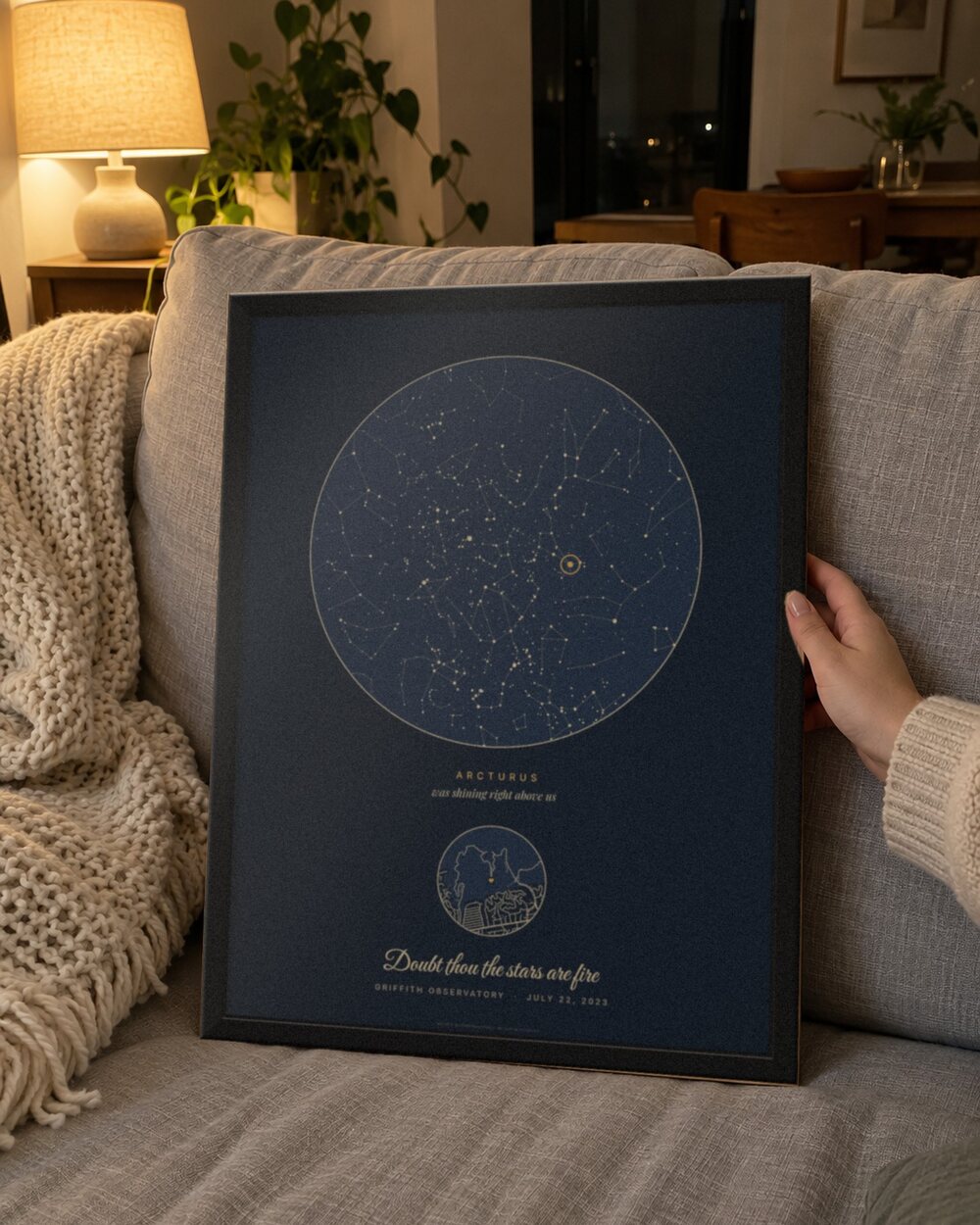 Star map with a quote in a black frame held on a sofa, an example: Our star in Navy for Griffith Observatory, July 22, 2023, Arcturus circled and the line Doubt thou the stars are fire under the sky